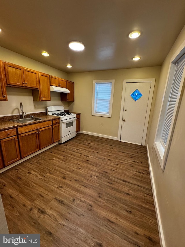 kitchen with dark hardwood / wood-style floors, white gas range, and sink