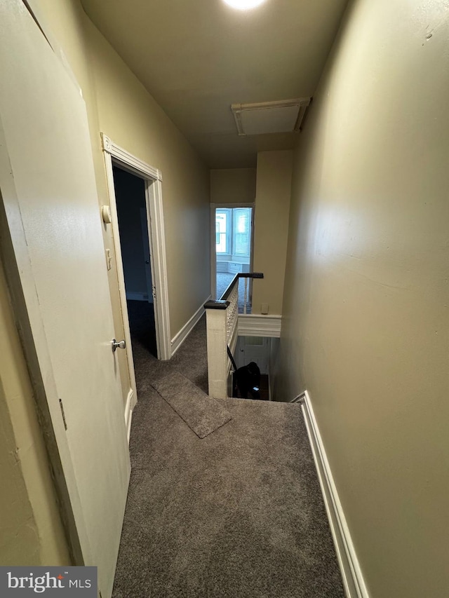 hall featuring dark colored carpet