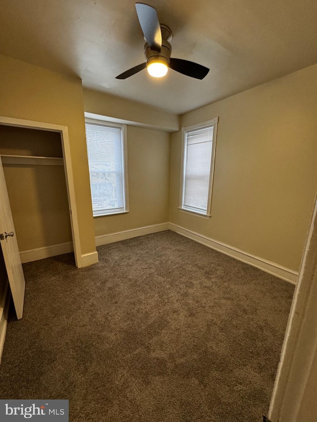 unfurnished bedroom featuring ceiling fan and dark carpet