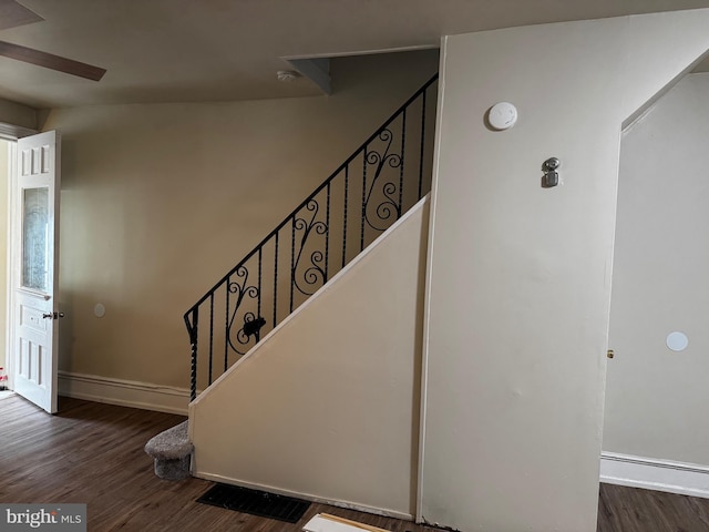 stairs featuring hardwood / wood-style flooring and ceiling fan