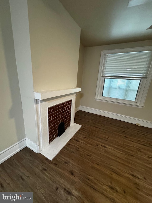 unfurnished living room with a fireplace and dark hardwood / wood-style floors