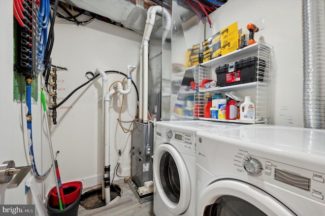 clothes washing area with wood-type flooring and separate washer and dryer