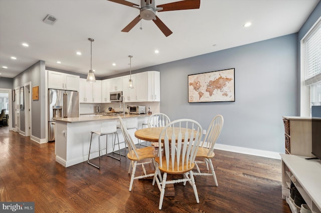 dining space featuring ceiling fan and dark wood-type flooring