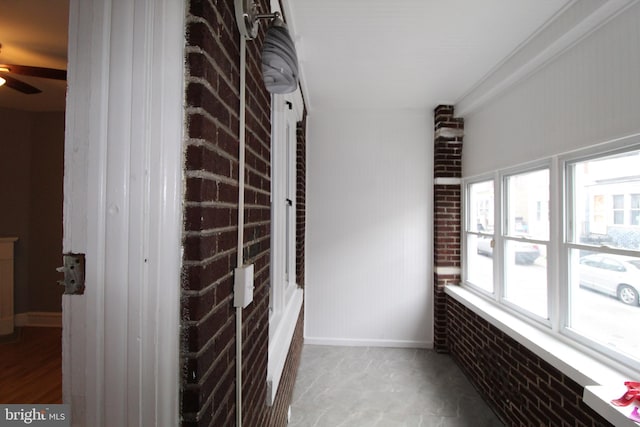 hall with brick wall and plenty of natural light