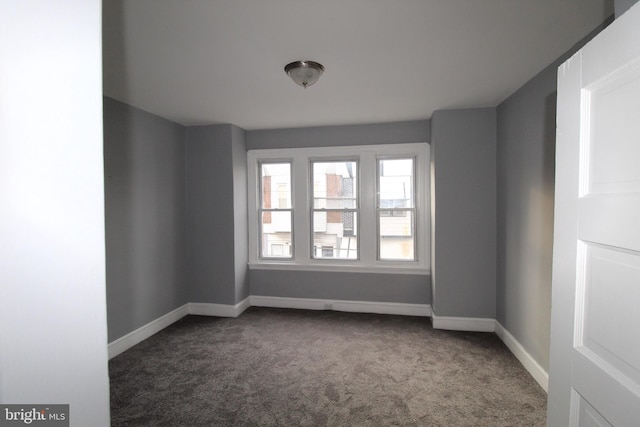 empty room featuring dark carpet