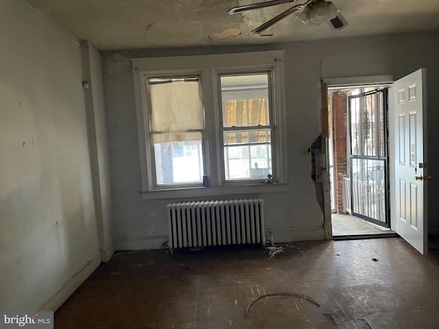 interior space featuring radiator heating unit and ceiling fan