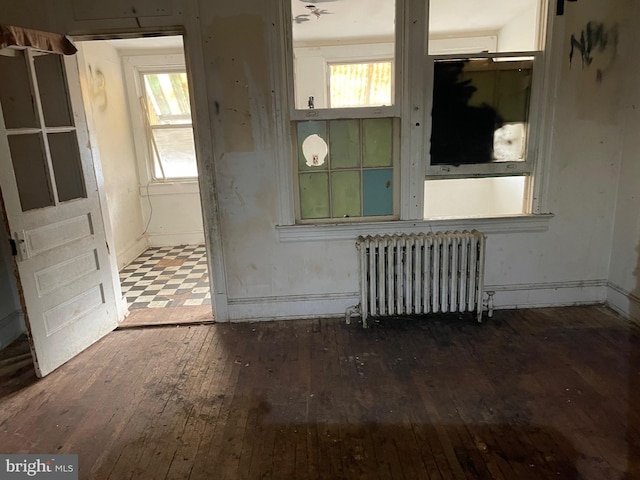 spare room with hardwood / wood-style floors and radiator heating unit