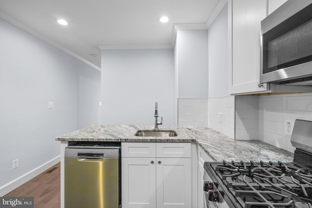 kitchen with white cabinets, sink, decorative backsplash, light stone counters, and stainless steel appliances