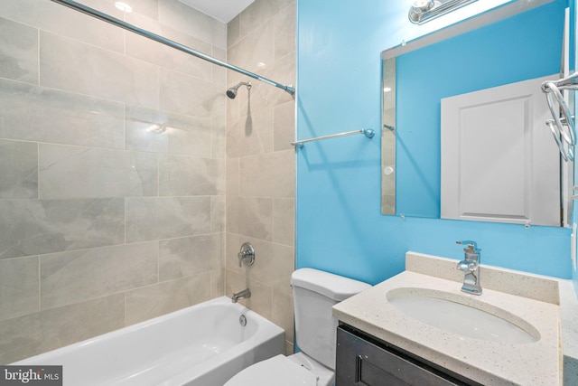 full bathroom featuring toilet, vanity, and tiled shower / bath