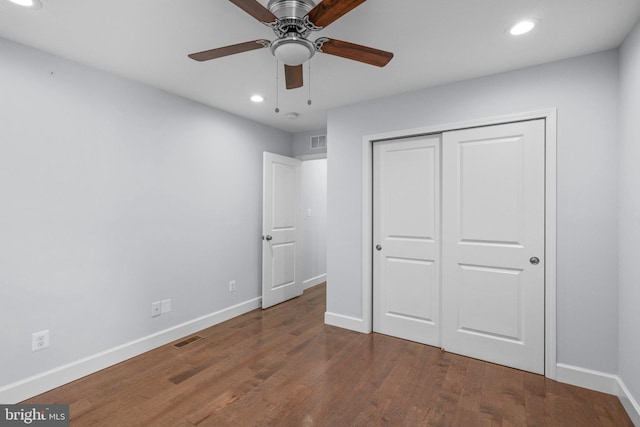 unfurnished bedroom featuring ceiling fan, dark hardwood / wood-style floors, and a closet