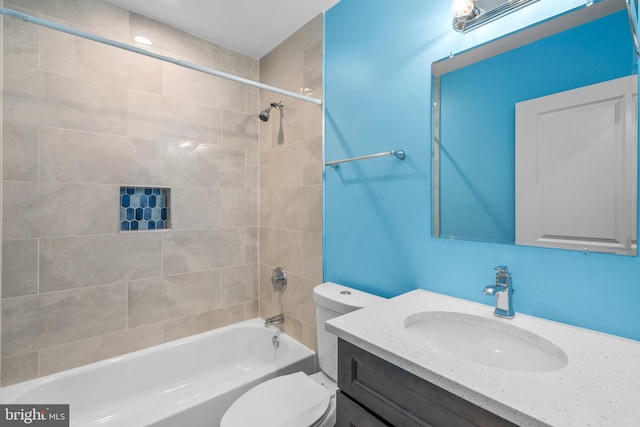 full bathroom with vanity, tiled shower / bath combo, and toilet