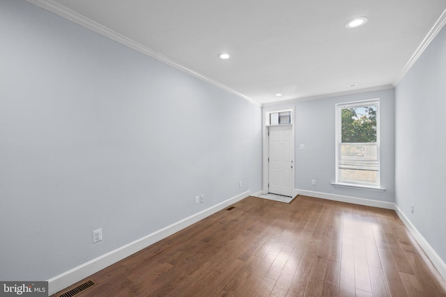 empty room featuring hardwood / wood-style flooring and ornamental molding