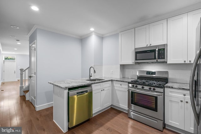 kitchen featuring white cabinets, stainless steel appliances, kitchen peninsula, and light stone counters