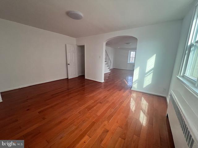 unfurnished room featuring radiator and hardwood / wood-style floors