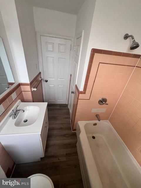 full bathroom featuring vanity, hardwood / wood-style flooring, toilet, and tiled shower / bath