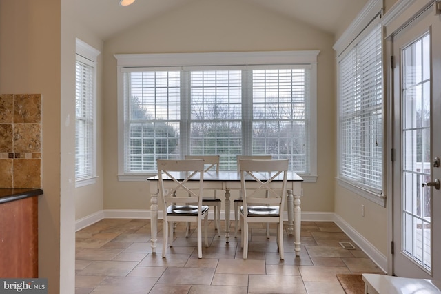 dining room featuring lofted ceiling and a wealth of natural light