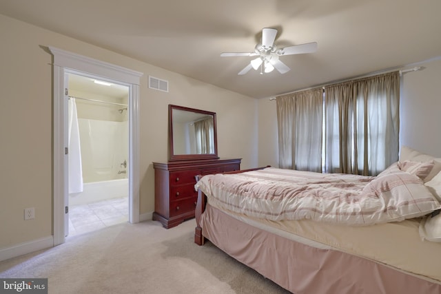 bedroom with ceiling fan, connected bathroom, and light carpet