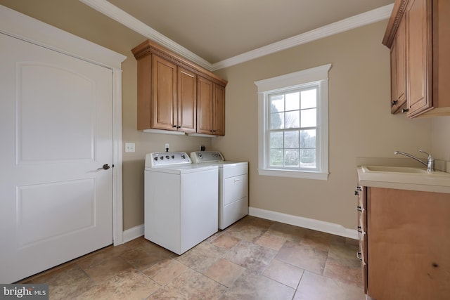 laundry area featuring cabinets, sink, ornamental molding, and washing machine and dryer