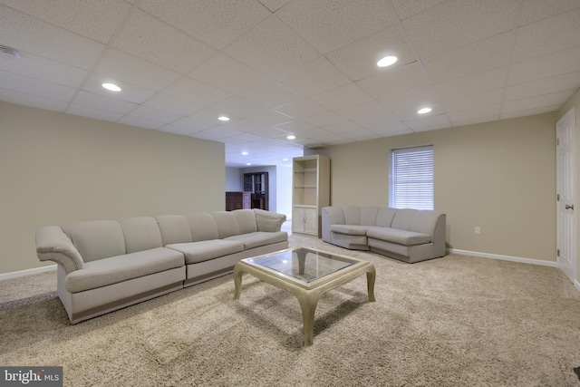 carpeted living room with a paneled ceiling