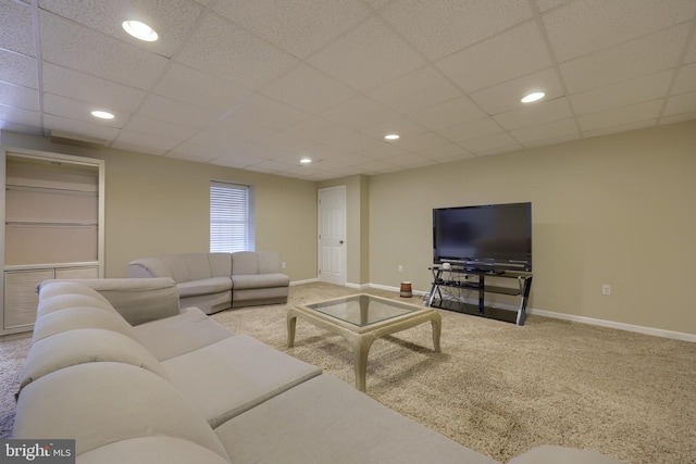 carpeted living room with a drop ceiling