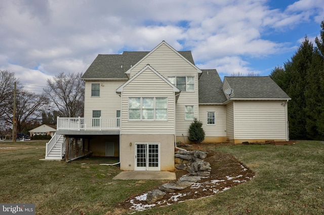 rear view of house with a lawn and a wooden deck