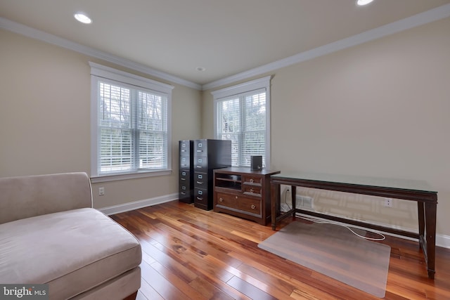 living area featuring ornamental molding and hardwood / wood-style flooring