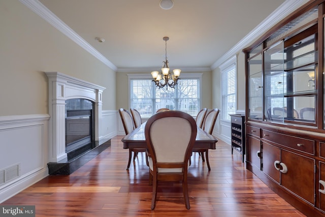 dining room with a chandelier, ornamental molding, and dark hardwood / wood-style flooring