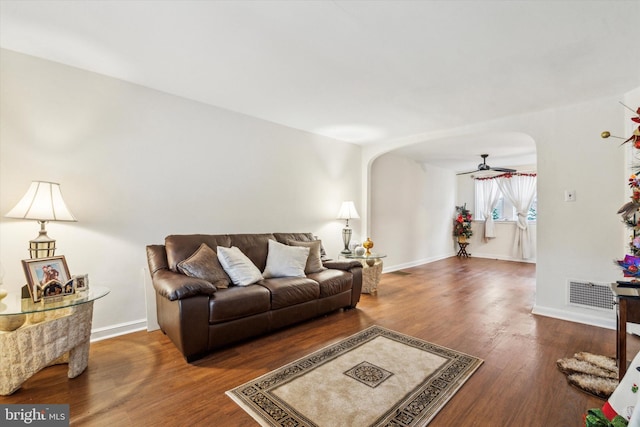 living room featuring ceiling fan and dark hardwood / wood-style floors