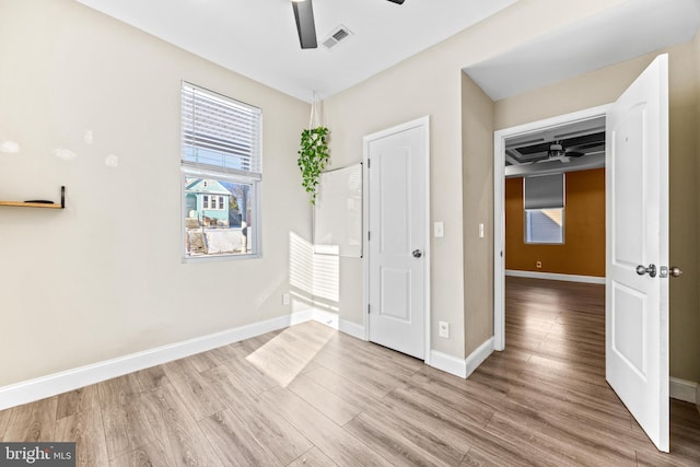 unfurnished bedroom featuring ceiling fan, light hardwood / wood-style floors, and a closet