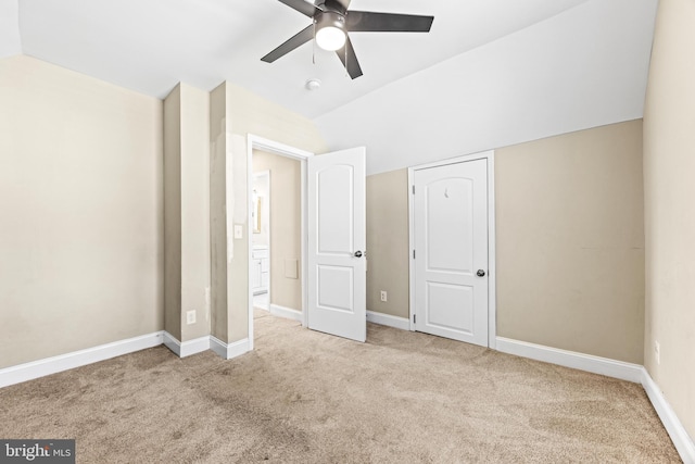 unfurnished bedroom with ceiling fan, light colored carpet, and lofted ceiling