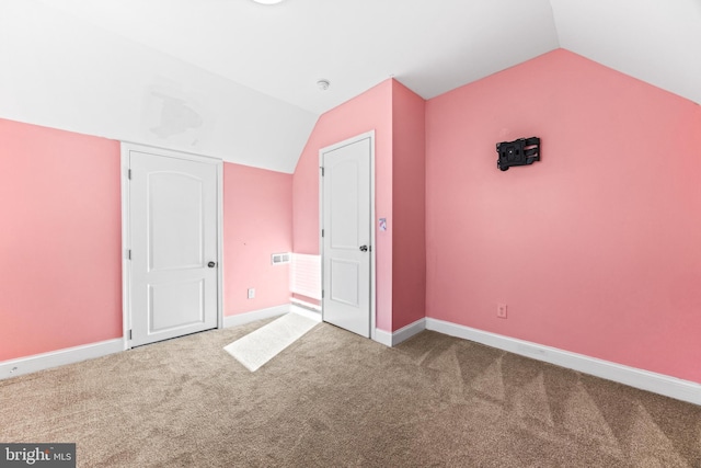 unfurnished bedroom with carpet flooring and vaulted ceiling