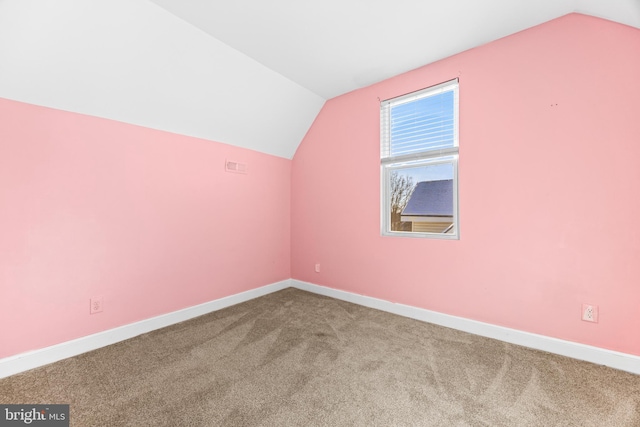 additional living space with carpet flooring and lofted ceiling