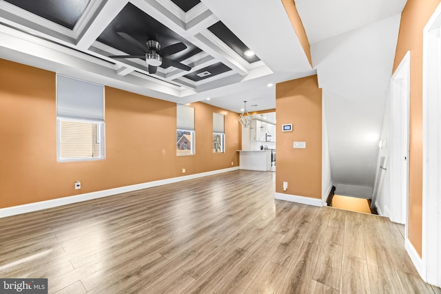 empty room with ceiling fan, light hardwood / wood-style floors, and coffered ceiling