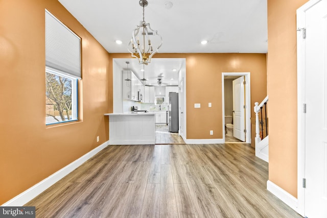 unfurnished dining area featuring light hardwood / wood-style floors and a chandelier