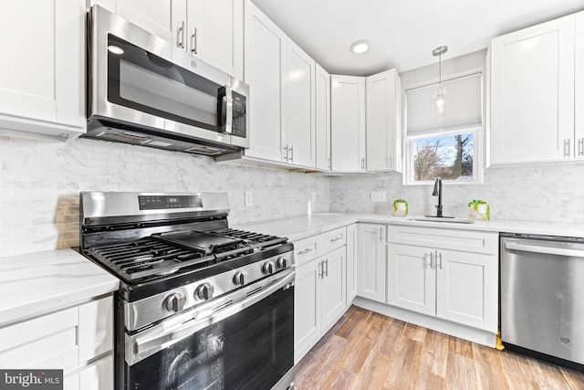 kitchen with white cabinets, backsplash, stainless steel appliances, and sink