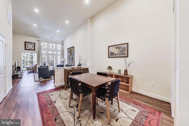 dining area featuring hardwood / wood-style flooring and high vaulted ceiling