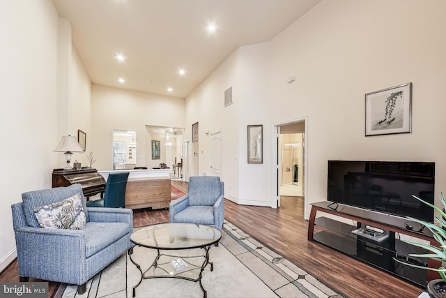 living room with wood-type flooring and a high ceiling