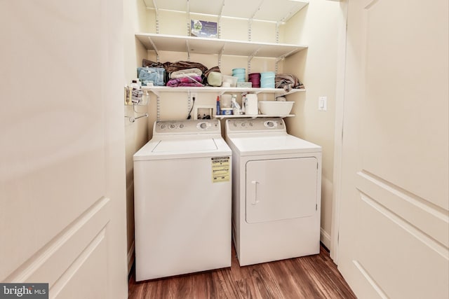 clothes washing area with washer and dryer and dark hardwood / wood-style flooring