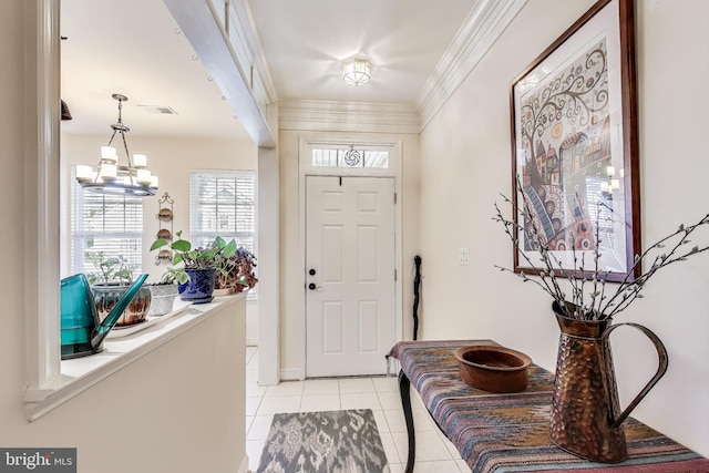 tiled foyer entrance with a notable chandelier and ornamental molding