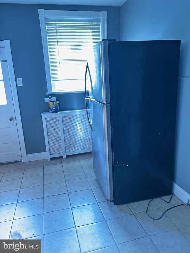 kitchen featuring light tile patterned floors and stainless steel refrigerator