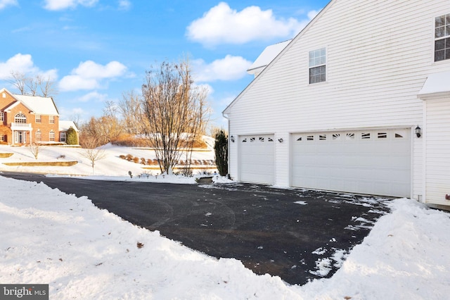 snow covered property with a garage