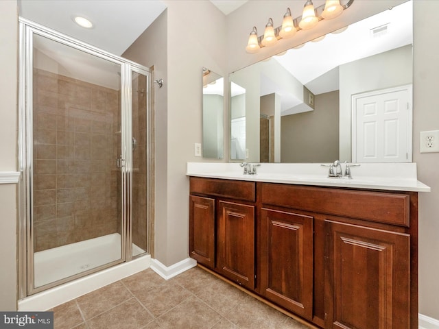 bathroom with a shower with door, vanity, and tile patterned flooring