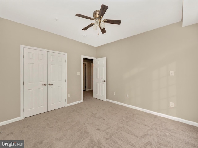 unfurnished bedroom featuring light carpet, a closet, and ceiling fan