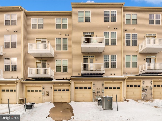 snow covered property with central AC