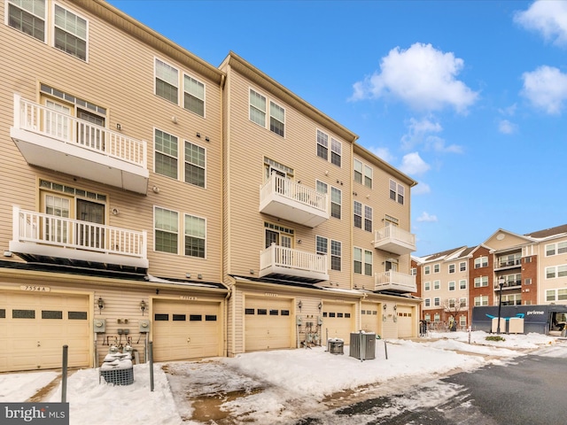 snow covered property with central air condition unit