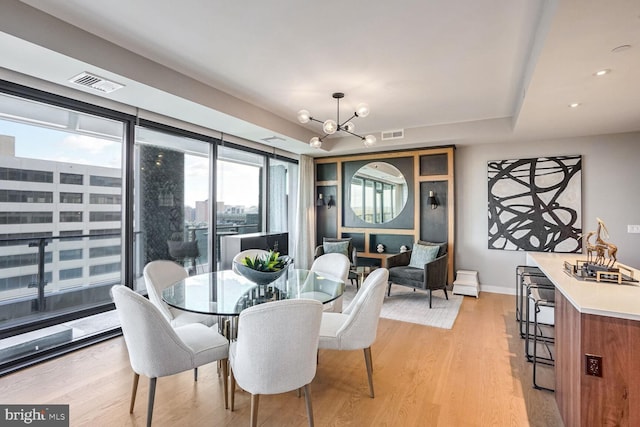 dining room featuring light wood-type flooring and a notable chandelier