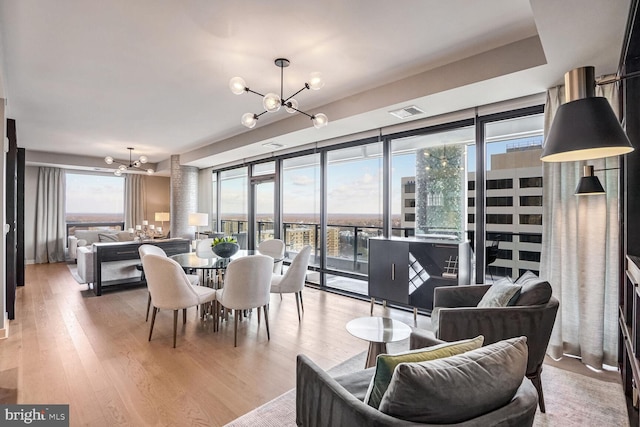 dining room with plenty of natural light, a chandelier, and light wood-type flooring