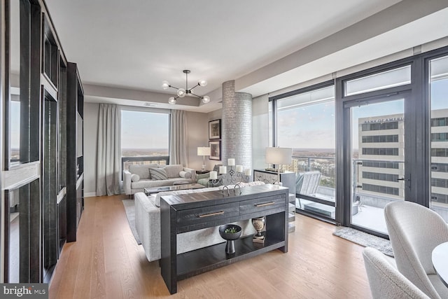 bedroom featuring access to outside, an inviting chandelier, and light hardwood / wood-style floors