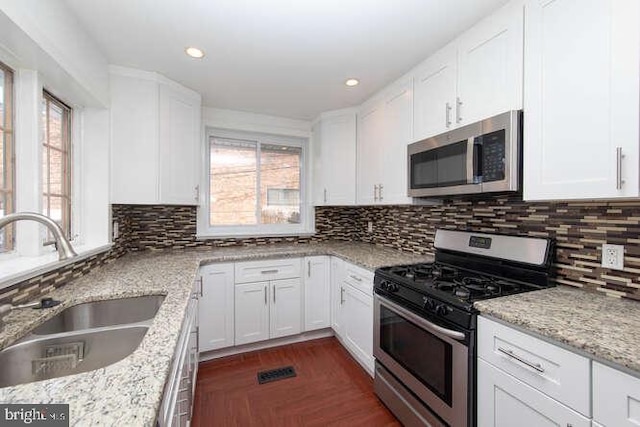 kitchen featuring light stone countertops, sink, white cabinets, and stainless steel appliances