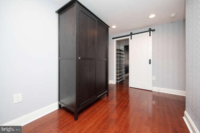 interior space featuring a barn door and dark hardwood / wood-style floors